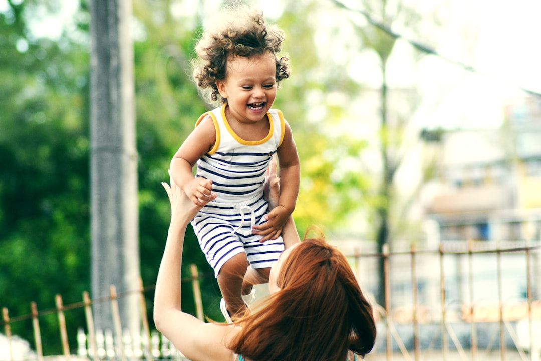 Air Happiness by Best Kids Tablets selective focus photo of woman lifting child during daytime