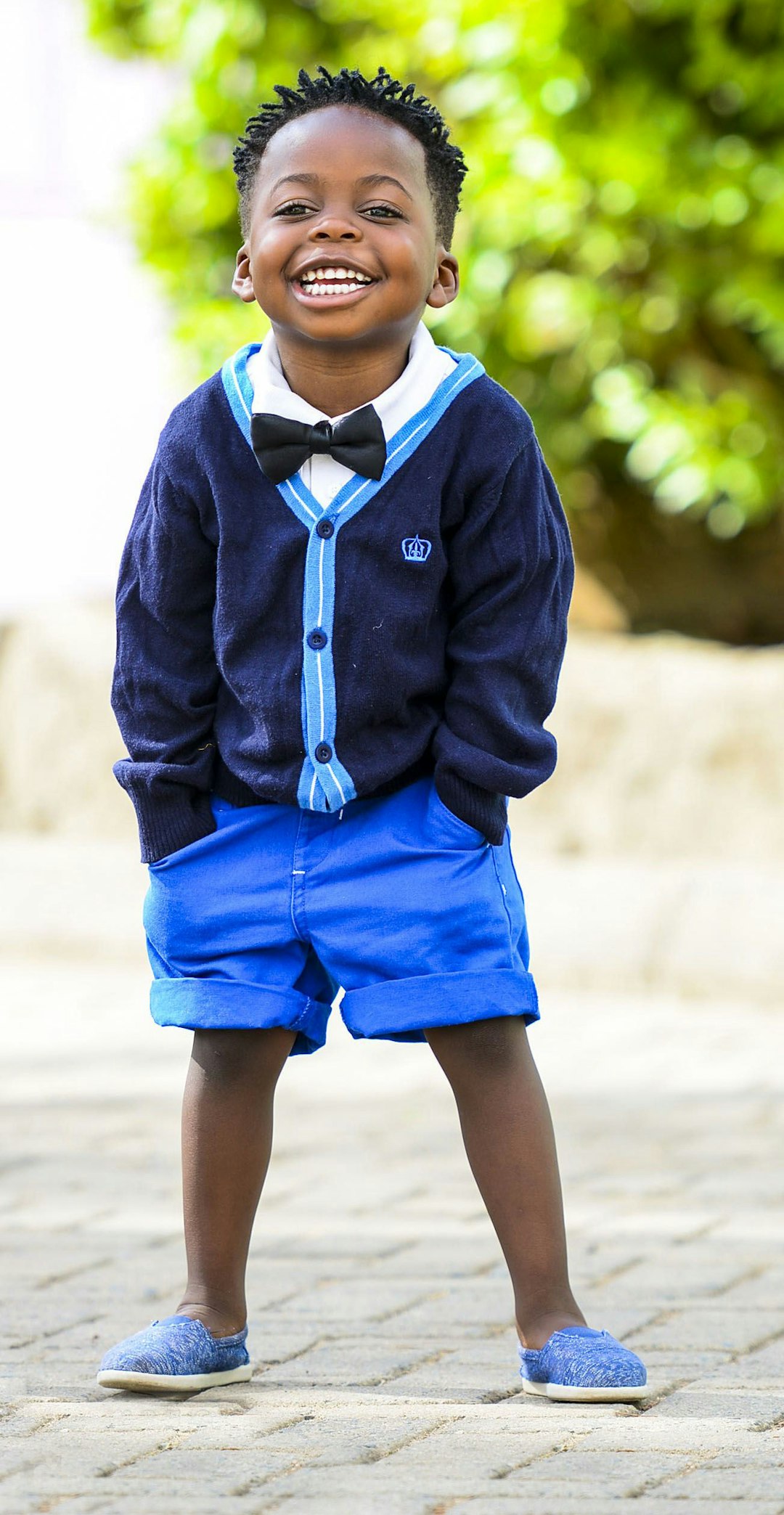 Smile for love by Best Kids Tablets selective focus photo of boy standing on grey pavement