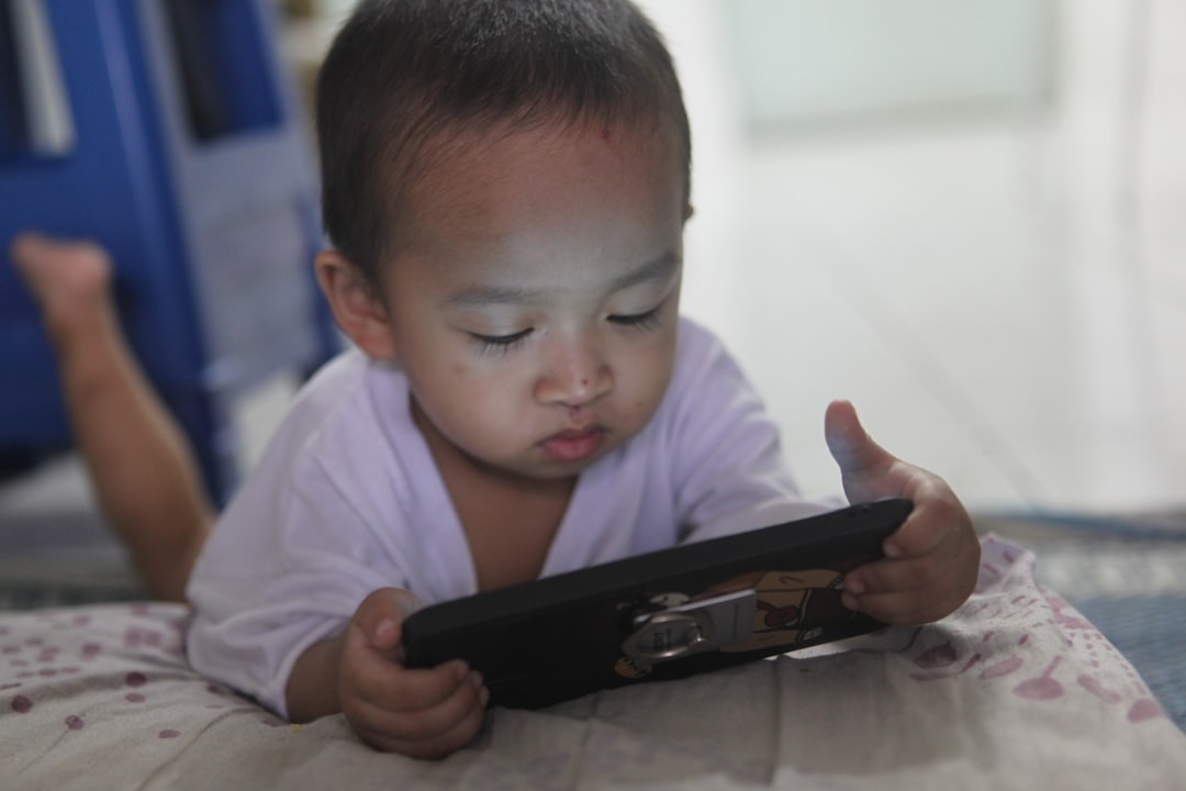 &Lianpi by Best Kids Tablets a small child laying on a bed playing with a tablet